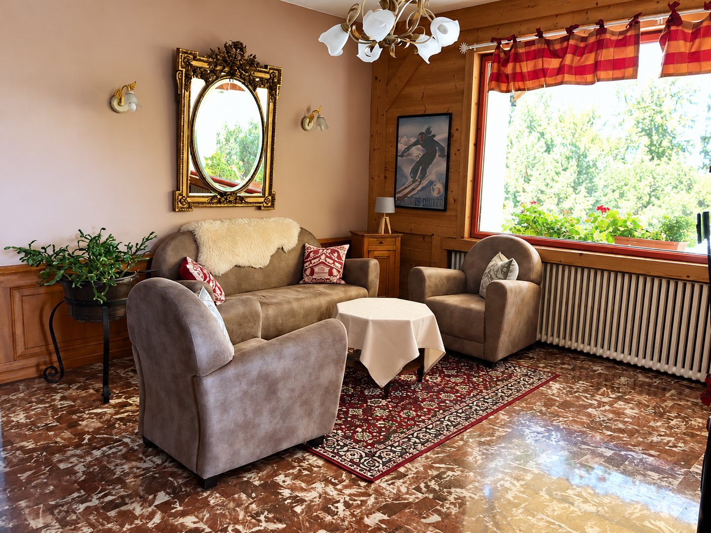 Salon de style chalet avec un canapé et deux fauteuils en tissu, une table basse, un miroir doré, une affiche de ski et une grande fenêtre.
